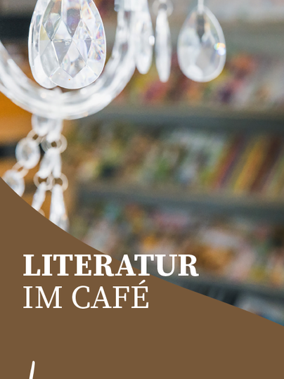 Ein schöner Kronleuchter mit Kristallhängern. Im Hintergrund sind Regale mit Büchern zu sehen.