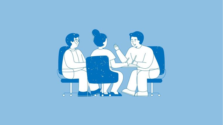 Drei Personen sitzen an einem Tisch und führen ein Gespräch. Sie scheinen interessiert und engaged zu sein.