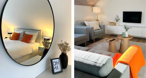 Une chambre élégante avec un grand miroir et un lit confortable. Dans le salon, il y a des meubles modernes et des éléments décoratifs.