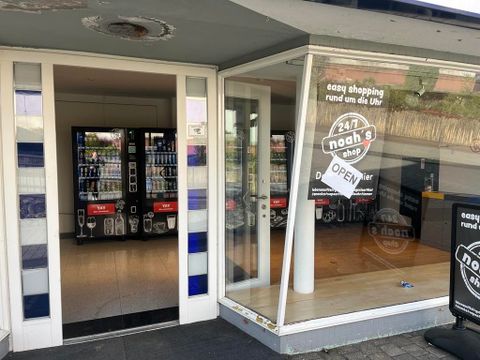Ein moderner Geschäftseingang mit einem transparenten Schaufenster. Das Geschäft ist rund um die Uhr geöffnet und bietet eine einfache Einkaufsmöglichkeit.