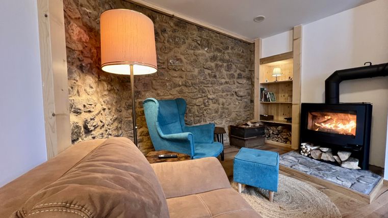 Un salon confortablement meublé avec un mur en terre battue et une cheminée, atmosphère confortable et bizarre