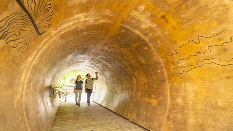 Ein Mann und eine Frau in einem Holztunnel mit einigen Einritzungen