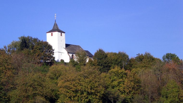 Old church of St. Apollonia in Gransdorf on a wooded hill.