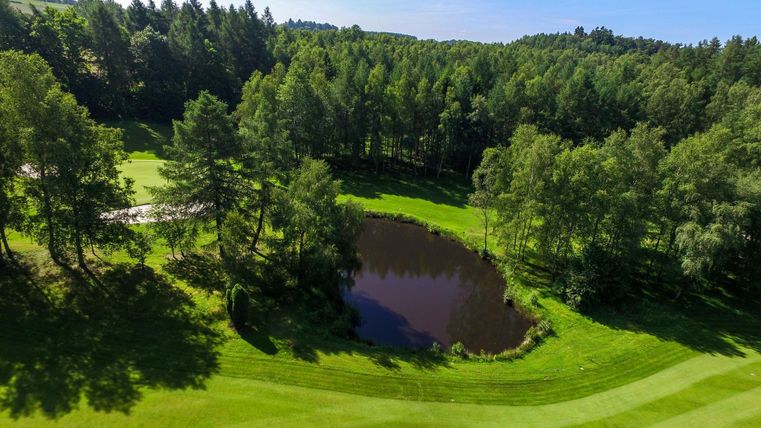 View from above of a golf course with a pond