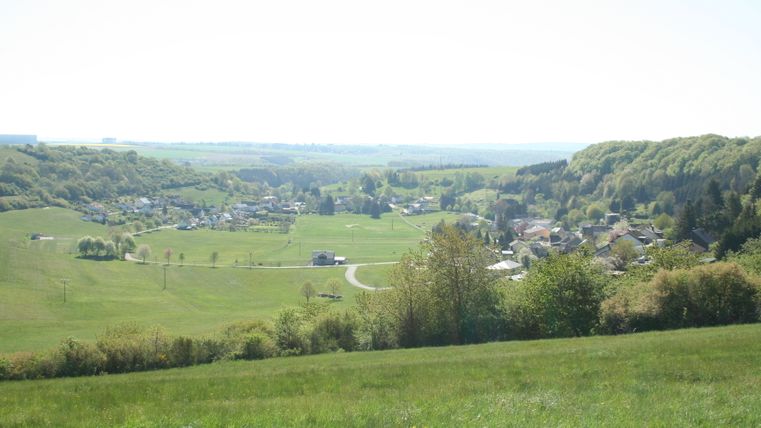 Vue panoramique sur le village d'Immerath dans un paysage verdoyant et vallonné.