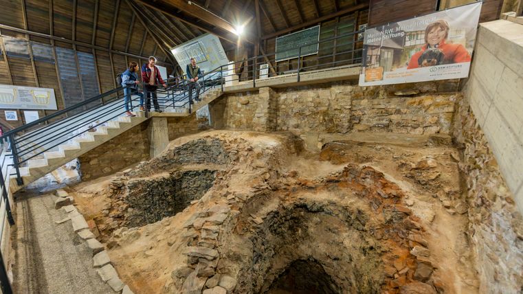 Interior view of the Roman lime kiln in Iversheim with visitors on a staircase.