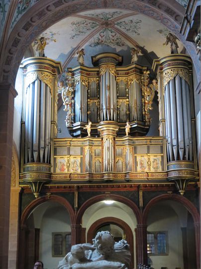 Eine prächtige Orgel in einem historischen Gebäude mit kunstvollen Verzierungen. Das Licht fällt sanft auf die Details der Architektur.