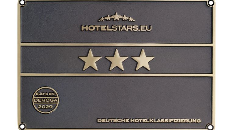 Een bord voor hotelclassificatie met drie sterren. Het heeft de opschrift "HOTELSTARS.EU" en "DUITSE HOTELKLASSIFICATIE".
