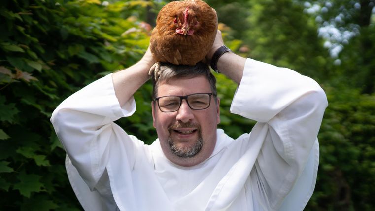 Zwei Männer sitzen in einem Raum. Sie lächeln und scheinen sich gut zu unterhalten.