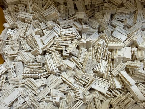 Ein Tischler arbeitet an einer Holzplatte mit einer Kreissäge. Holzspäne und Staub fliegen in der Luft.