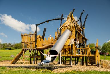 Kinder spielen auf einem Spielplatz auf einem Spielgerät das wie eine Burg aussieht