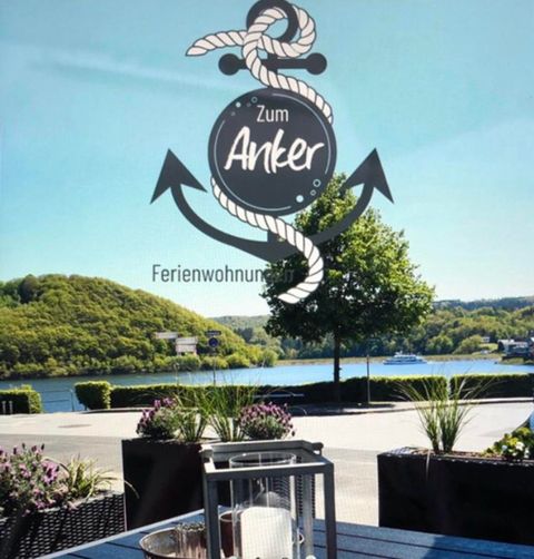 A modern apartment with an open kitchen and a cozy living area. The furniture is in neutral colors, with two small tables in the center.