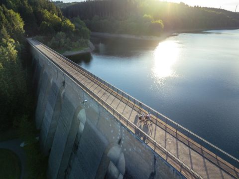 Luchtfoto van de Oleftalsperre stuwdam in Hellenthal met fietsers op de stuwdamwand.