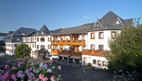 Un charmant hôtel avec plusieurs étages et de beaux balcons. L'environnement est vert et bien entretenu, idéal pour un séjour détente.