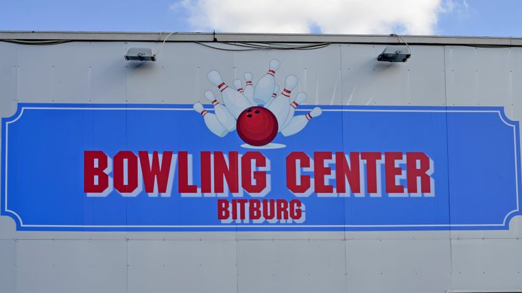 Een bord voor het Bowling Center in Bitburg. Het toont een bowlingbal en kegels op een blauwe achtergrond.