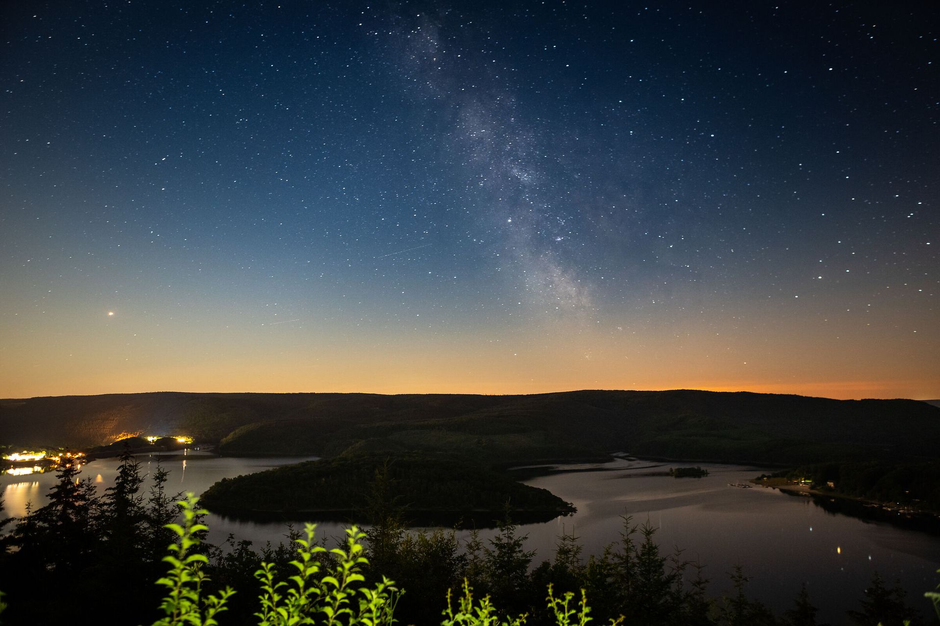 ein dunkles Bild, dass Sterne zeigt, darunter ein See