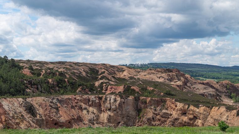 Landscape with open-cast mine and cloudy sky in the Eifel.