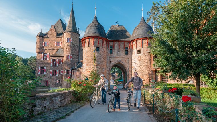 Familie mit Fahrrädern vor Burg Satzvey.