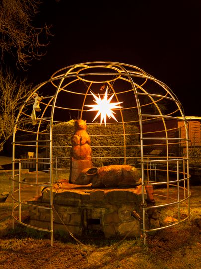 Een kunstzinnige lichtinstallatie in een afgerond frame, die een beer voorstelt. De ster straalt in het donker en creëert een feestelijke sfeer.