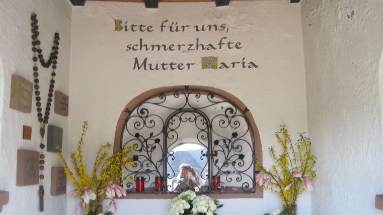 Petite chapelle avec des fleurs et l'inscription 'Priez pour nous, Marie, mère douloureuse'.