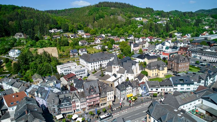 Hauptstraße mit Häusern in Adenau im Hintergrund Wald 