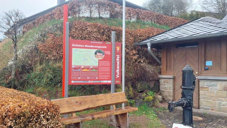 Starttafel am Dorfplatz Kerschenbach mit Wanderkarte und Sitzbank.