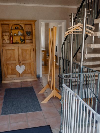 Ein heller Flur mit einem Schrank und einer Treppe.