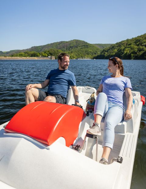 Zwei Personen fahren auf einem Tretboot auf dem Rursee