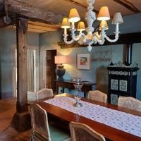 A cozy dining area with a large wooden table and elegant chairs. A decorative ceiling light and a stylish sideboard add charm to the space.