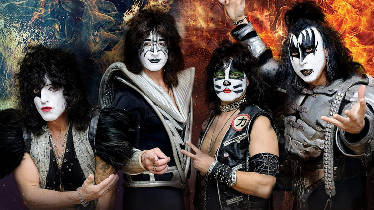 Een rockband met opvallende make-up en extravagante kostuums. De leden poseren dynamisch voor een kleurrijke achtergrond.