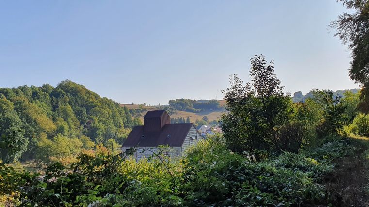 Paysage avec un vieux moulin et des arbres au premier plan.