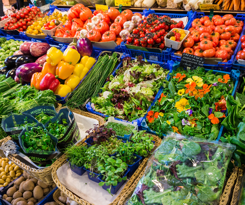 A large selection of vegetables is displayed. Salad, tomatoes, and potatoes are visible.