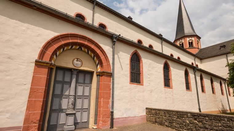 Exterior view of Steinfeld Abbey with archway and church tower.