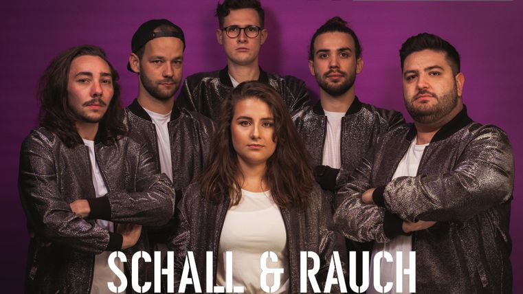 A band called "Schall & Rauch" with six members in metallic jackets stands in front of a purple background. They all look at the camera and radiate an energetic atmosphere.