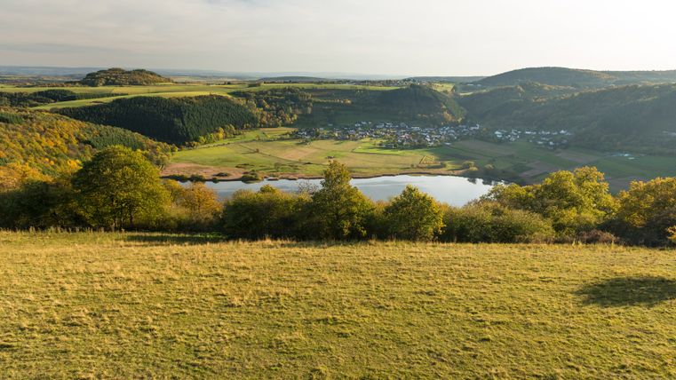 Landschaft mit Blick auf das Meerfelder Maar und umliegende Hügel.