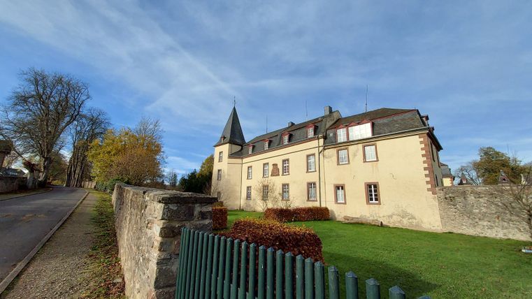 Kasteel Schmidtheim met tuin en blauwe lucht.