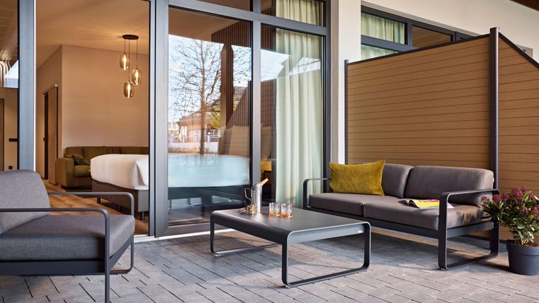 Une terrasse moderne avec des meubles élégants. L'espace est lumineux et accueillant, idéal pour se détendre.