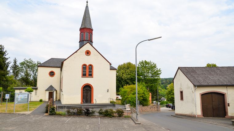 Église de Wißmannsdorf avec parking et rue environnante.
