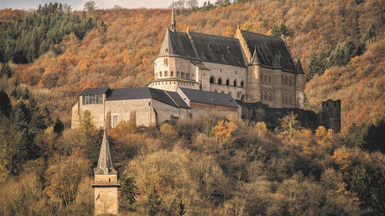 Le château de Vianden au milieu des arbres en automne.