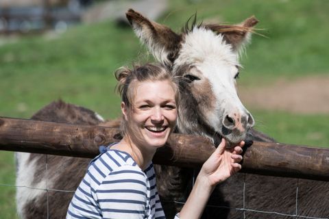 Eine lachende Frau mit Esel