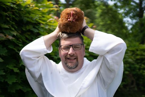 Zwei Männer sitzen in einem Raum. Sie lächeln und scheinen sich gut zu unterhalten.