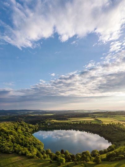 Luftaufnahme eines fast runden Sees, dem Weinfelder Maar