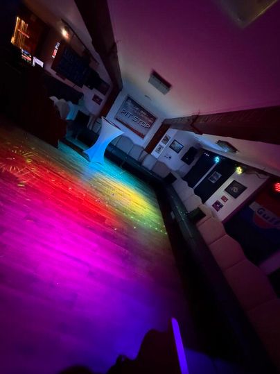 Een interieur met kleurrijke lichten op de houten vloer. De omgeving voelt gezellig en uitnodigend aan.