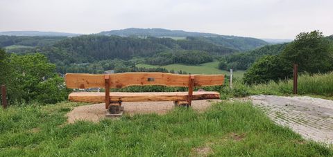 Een grote houten bank van achteren gefotografeerd met uitzicht op 