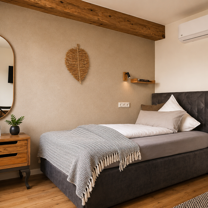 A stylish bedroom with a comfortable bed and a large mirror. The warm wood accents and modern decor create an inviting atmosphere.