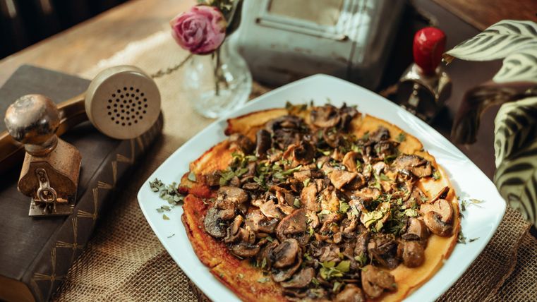 Champignonpizza op een wit bord.