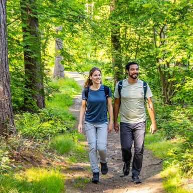 Mann und Frau wandern durch einen Wald
