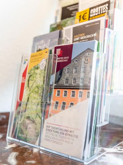 A flyer stand with various brochures about local attractions and historical topics. The brochures are designed to be colorful and informative.