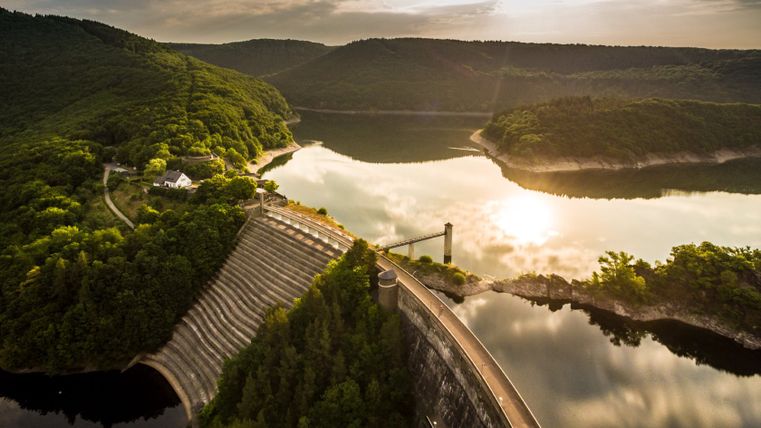 Aerial view of the Urft Dam in the Eifel National Park at sunset.