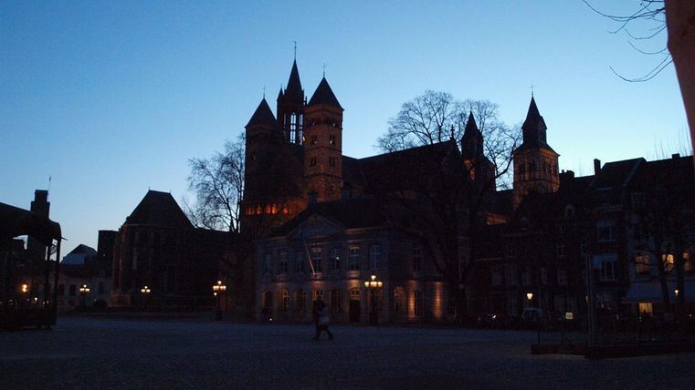 Eine malerische Stadtansicht bei Dämmerung mit silhouettierten Gebäuden. Der Himmel ist klar und zeigt sanfte Blautöne.